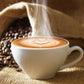 Cup of coffee in a white mug with coffee beans in background